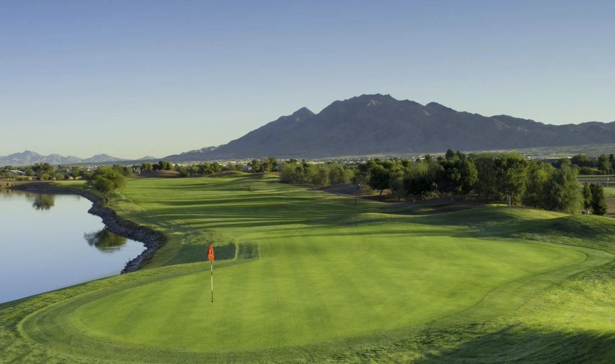 A green beside water at Stallion Mountain, with the mountains behind